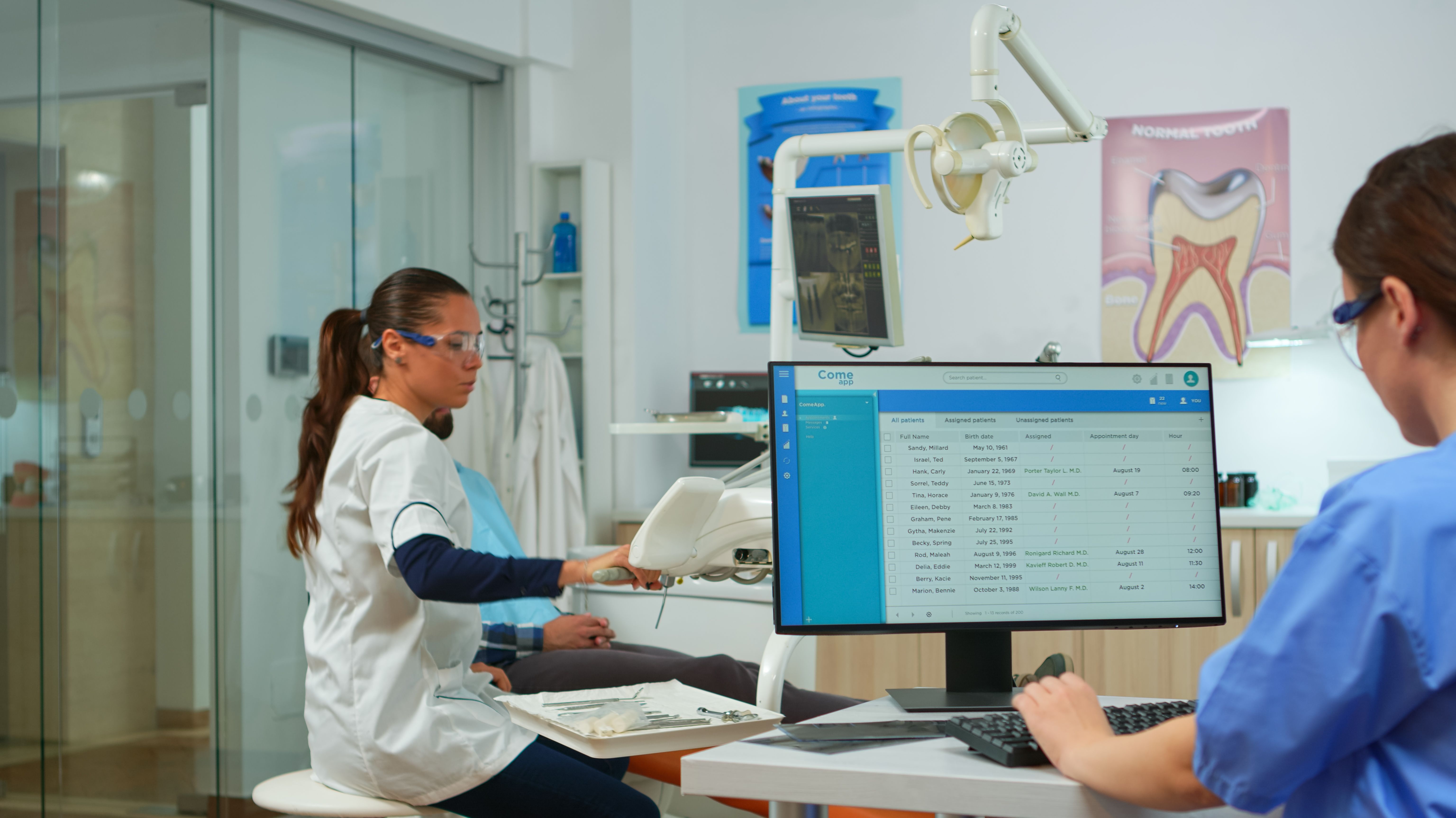 nurse-typing-computer-making-appointments-while-dental-specialist-talking-patient-stomatology-chair-before-examination-dentist-nurse-working-together-modern-stomatological-clinic